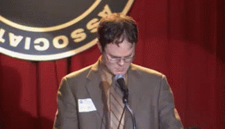 A Man In A Suit Is Speaking Into A Microphone In Front Of A Sign That Says " Social " GIF