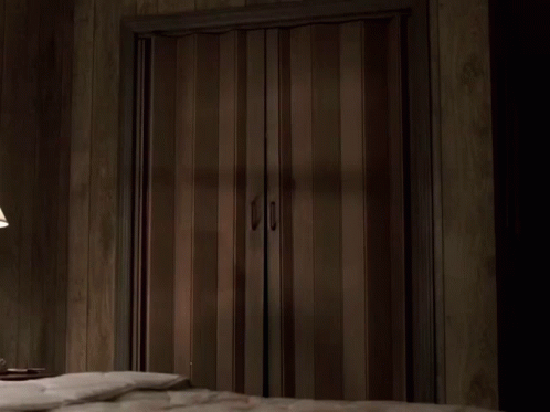 A Man In A Suit Is Standing In A Doorway GIF