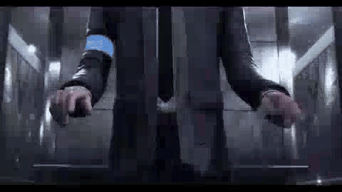a man in a suit is standing in an elevator with his hands on the buttons .