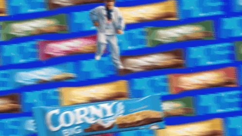 A Man In A Suit Is Standing In Front Of A Box Of Corny Big GIF