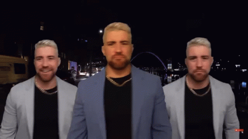 A Man In A Suit Is Standing In Front Of A City Skyline GIF