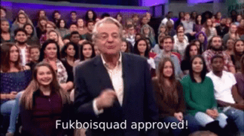 A Man In A Suit Is Standing In Front Of A Crowd . GIF