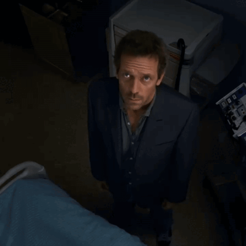 A Man In A Suit Is Standing In Front Of A Machine That Says ' Ecg ' On It GIF