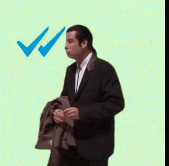A Man In A Suit Is Standing In Front Of A Microphone With A Blue Check Mark . GIF