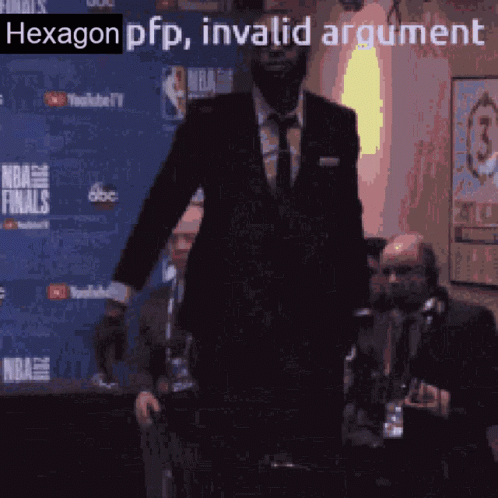 A Man In A Suit Is Standing In Front Of A Nba Finals Banner GIF