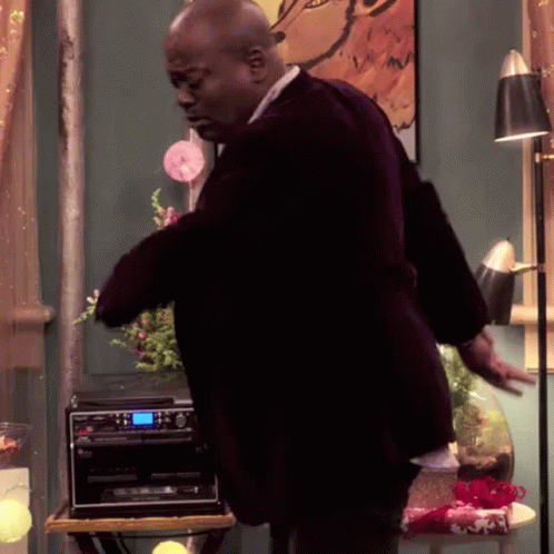 A Man In A Suit Is Standing In Front Of A Pioneer Stereo GIF