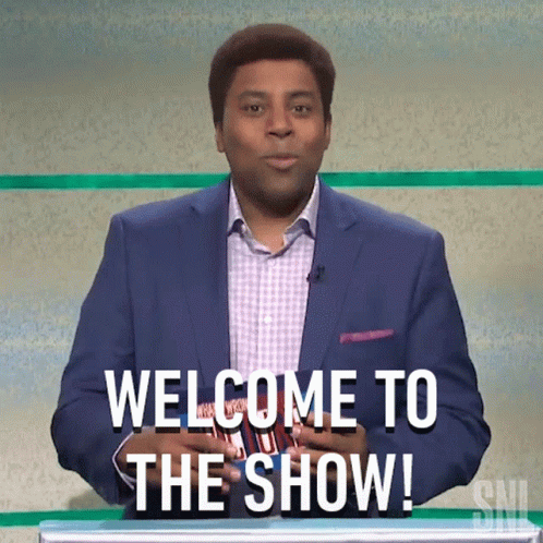 A Man In A Suit Is Standing In Front Of A Podium And Saying Welcome To The Show GIF
