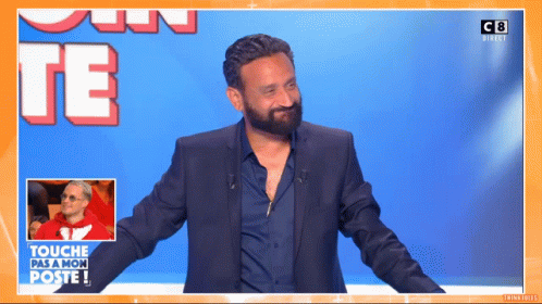 A Man In A Suit Is Standing In Front Of A Sign That Says Touche Pas A Mon Poste GIF