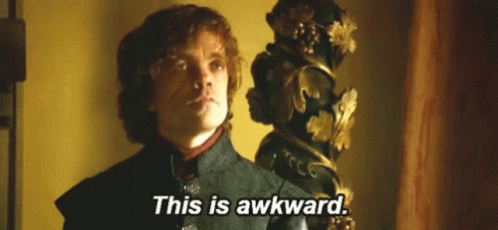 A Man In A Suit Is Standing In Front Of A Statue And Says `` This Is Awkward '' . GIF