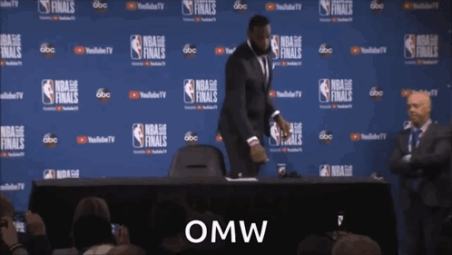 a man in a suit is standing in front of a wall that says nba finals