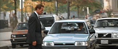 A Man In A Suit Is Standing Next To A Car With A License Plate That Says California GIF
