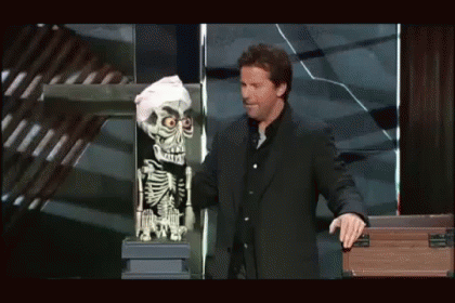 A Man In A Suit Is Standing Next To A Skeleton Puppet GIF