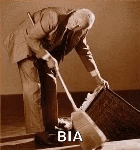 A Man In A Suit Is Sweeping The Floor With A Broom And A Bucket . GIF