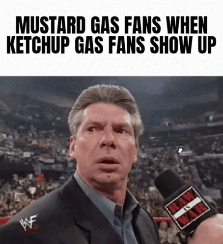 A Man In A Suit Is Talking Into A Microphone With The Words Mustard Gas Fans When Ketchup Gas Fans Show Up On The Bottom GIF