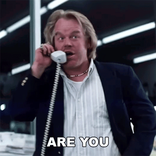 A Man In A Suit Is Talking On A Phone And Says Are You GIF