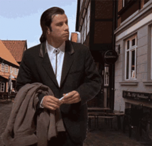 a man in a suit is walking down a street in front of a building with a sign that says kaiser 's