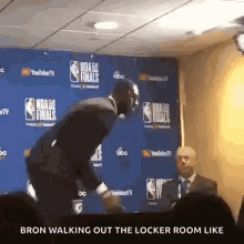 a man in a suit is walking out of a locker room like a basketball player .