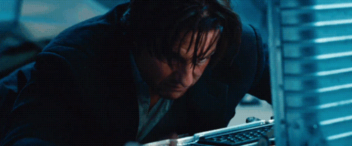 A Man In A Suit Looks At A Computer Screen GIF