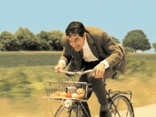 A Man In A Suit Rides A Bike With A Basket Full Of Food GIF