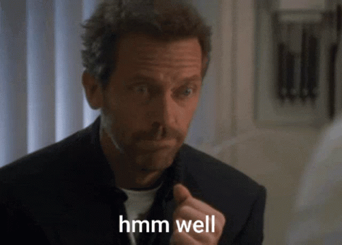 A Man In A Suit Says Hmm Well GIF