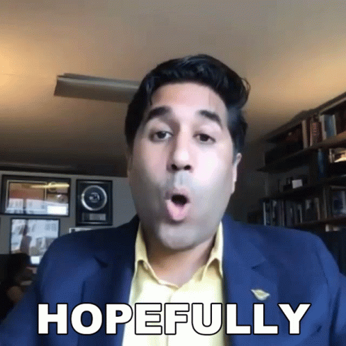 A Man In A Suit Says Hopefully In Front Of A Bookshelf GIF