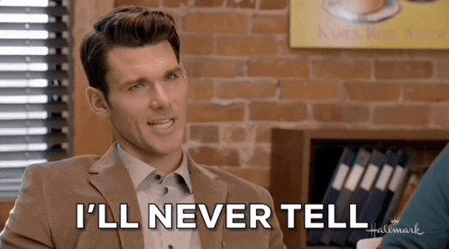A Man In A Suit Says " I 'Ll Never Tell " In Front Of A Brick Wall GIF