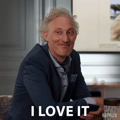 A Man In A Suit Says I Love It While Holding A Cellphone GIF