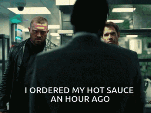 A Man In A Suit Says I Ordered My Hot Sauce An Hour Ago In A Dark Room GIF