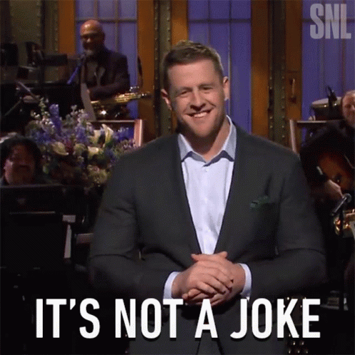 A Man In A Suit Says " It 'S Not A Joke " In Front Of An Orchestra GIF