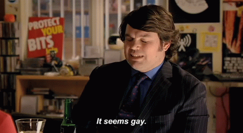 A Man In A Suit Says It Seems Gay In Front Of A Sign That Says Protect Your Bits GIF