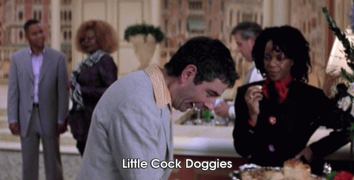 A Man In A Suit Says Little Cock Doggies In Front Of A Group Of People . GIF