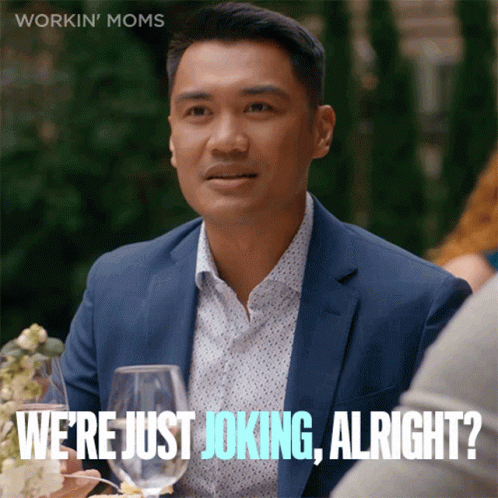 A Man In A Suit Says " We 'Re Just Joking Alright " While Sitting At A Table With Wine Glasses GIF