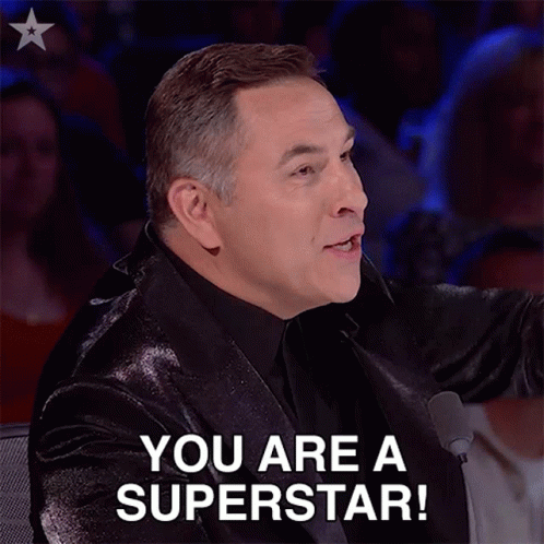 A Man In A Suit Says " You Are A Superstar " In Front Of A Microphone GIF