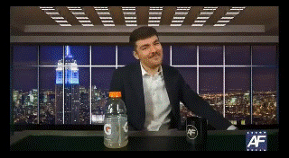 A Man In A Suit Sits At A Table With A Bottle Of Gatorade GIF