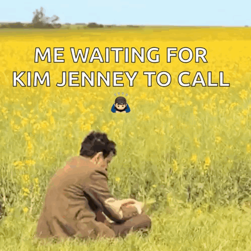 A Man In A Suit Sits In A Field Of Yellow Flowers Waiting For Kim Jenney To Call Him GIF