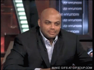 a man in a suit sitting in front of a hyundai sign