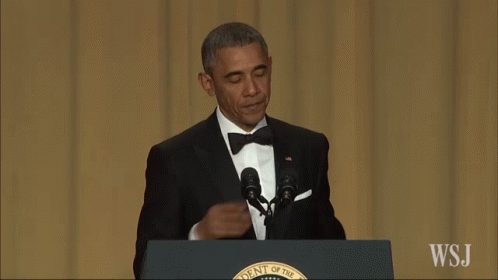 A Man In A Suit Stands At A Podium That Says Wsj On It GIF