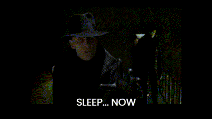 A Man In A Suit Stands In A Dark Room And Says Sleep Now GIF