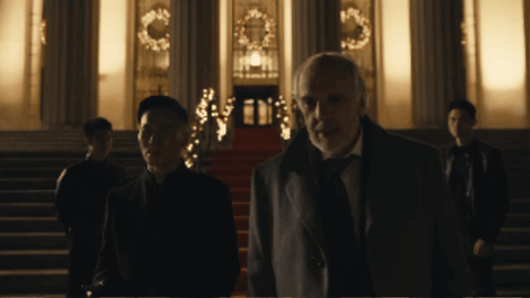 A Man In A Suit Stands In Front Of A Building GIF