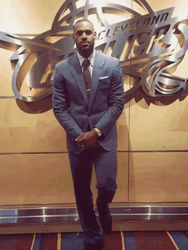 a man in a suit stands in front of a cleveland thunder sign
