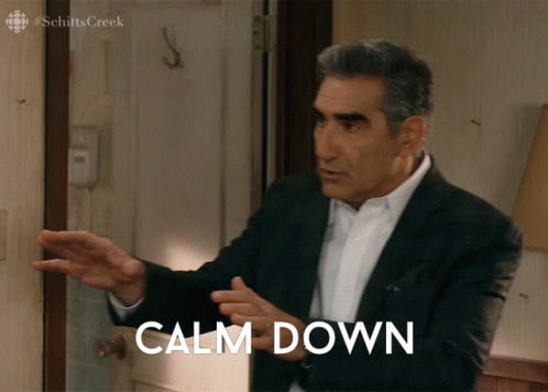 a man in a suit stands in front of a door with calm down written on it