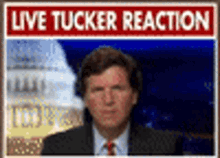 A Man In A Suit Stands In Front Of A Live Tucker Reaction Sign GIF