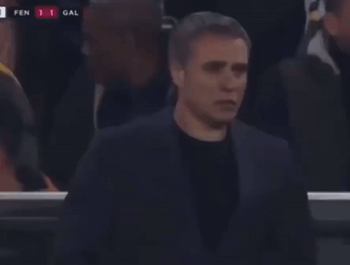 A Man In A Suit Stands In Front Of A Scoreboard That Says Fen 1 Gal On It GIF