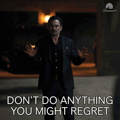 A Man In A Suit Stands In Front Of A Sign That Says " Don 'T Do Anything You Might Regret " GIF