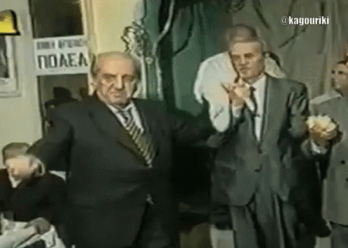 A Man In A Suit Stands In Front Of A Sign That Says Polea GIF
