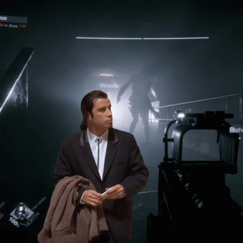 A Man In A Suit Stands In Front Of A Sign That Says " Woods " GIF