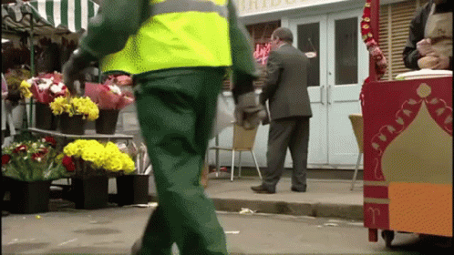 A Man In A Suit Stands In Front Of A Store That Has The Word Bride On It GIF