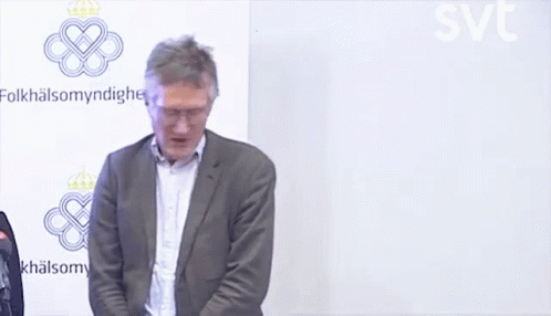 A Man In A Suit Stands In Front Of A Wall That Says Folkhälsomyndigheten GIF