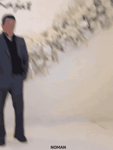 A Man In A Suit Stands In Front Of A Wall That Says Rita & Rajat GIF