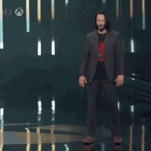 A Man In A Suit Stands On A Stage With The Words You 'Re Breathtaking Behind Him GIF